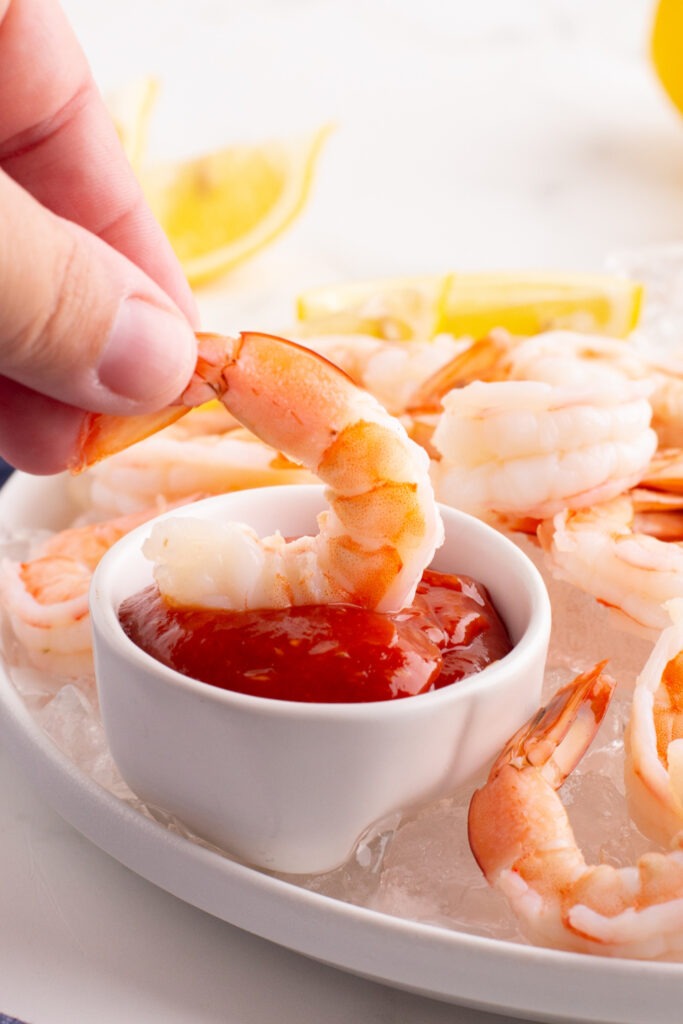 dipping shrimp into cocktail sauce