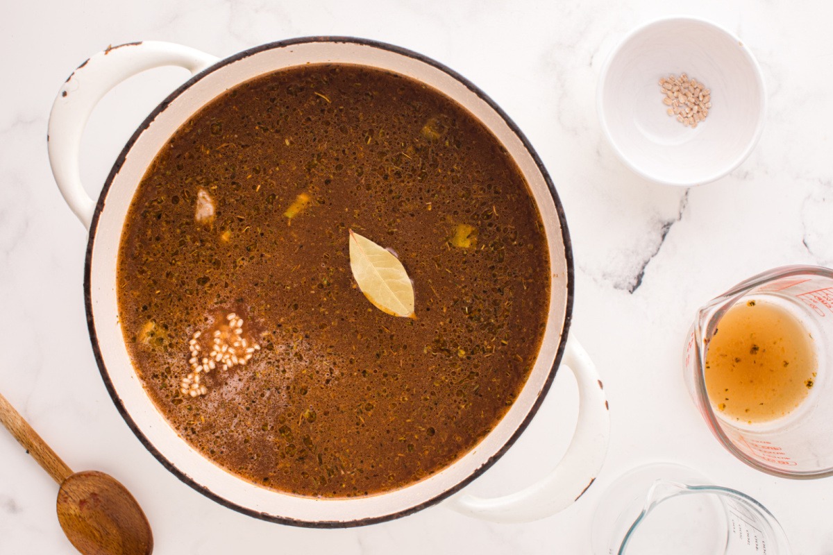 broth and bay leaf in widow to pot