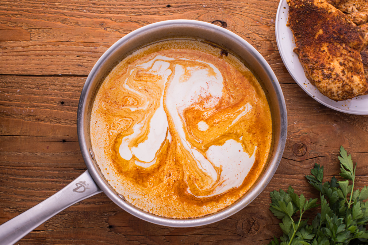 adding heavy cream to the pan