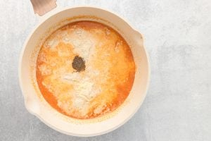 Grated Parmesan cheese and shredded mozzarella cheese added to pan