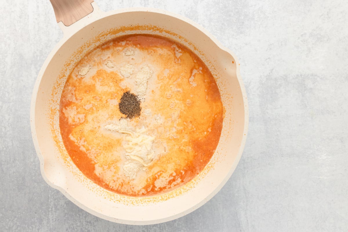 Grated Parmesan cheese and shredded mozzarella cheese added to pan