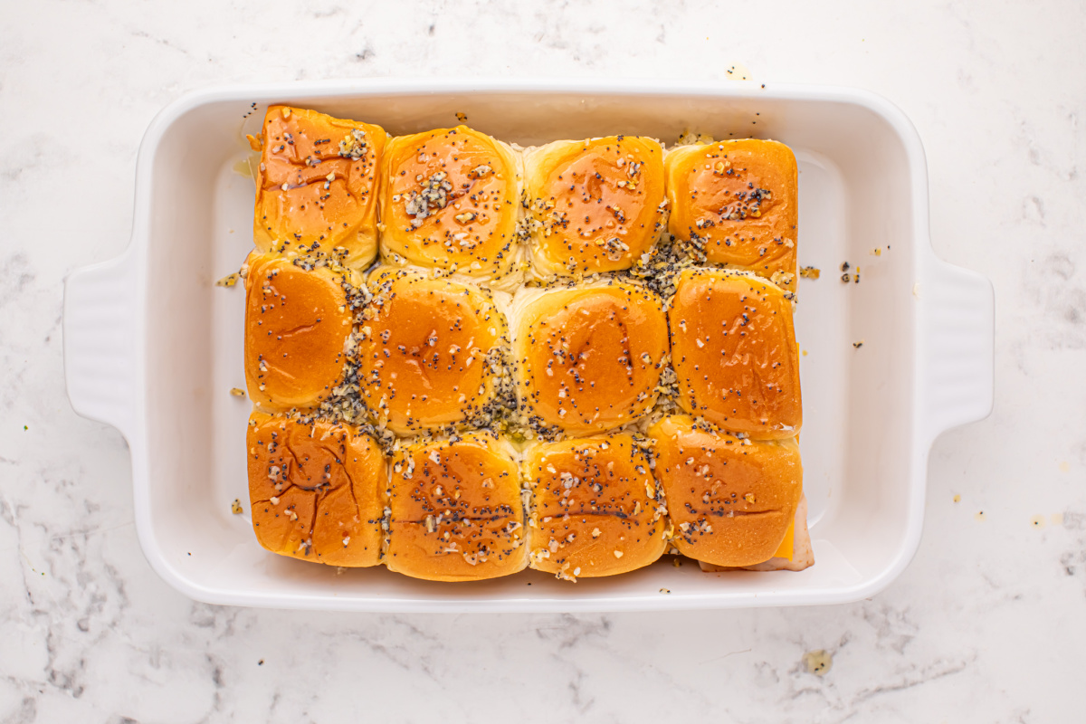 melted butter, minced dried onion and poppy seeds mixture on top of buns