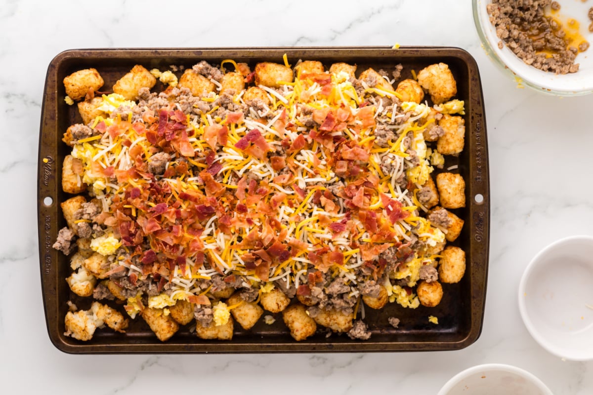 eggs, cheese, bacon and breakfast sausage added to top of tater tots