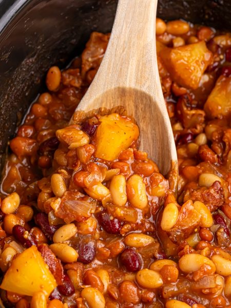 slow cooker hawaiian baked beans in slow cooker with wooden spoon