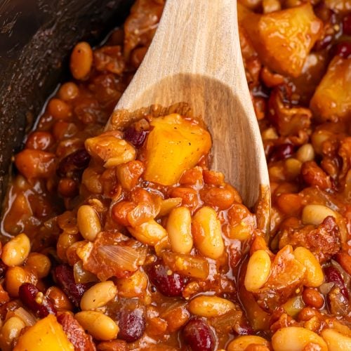 slow cooker hawaiian baked beans in slow cooker with wooden spoon