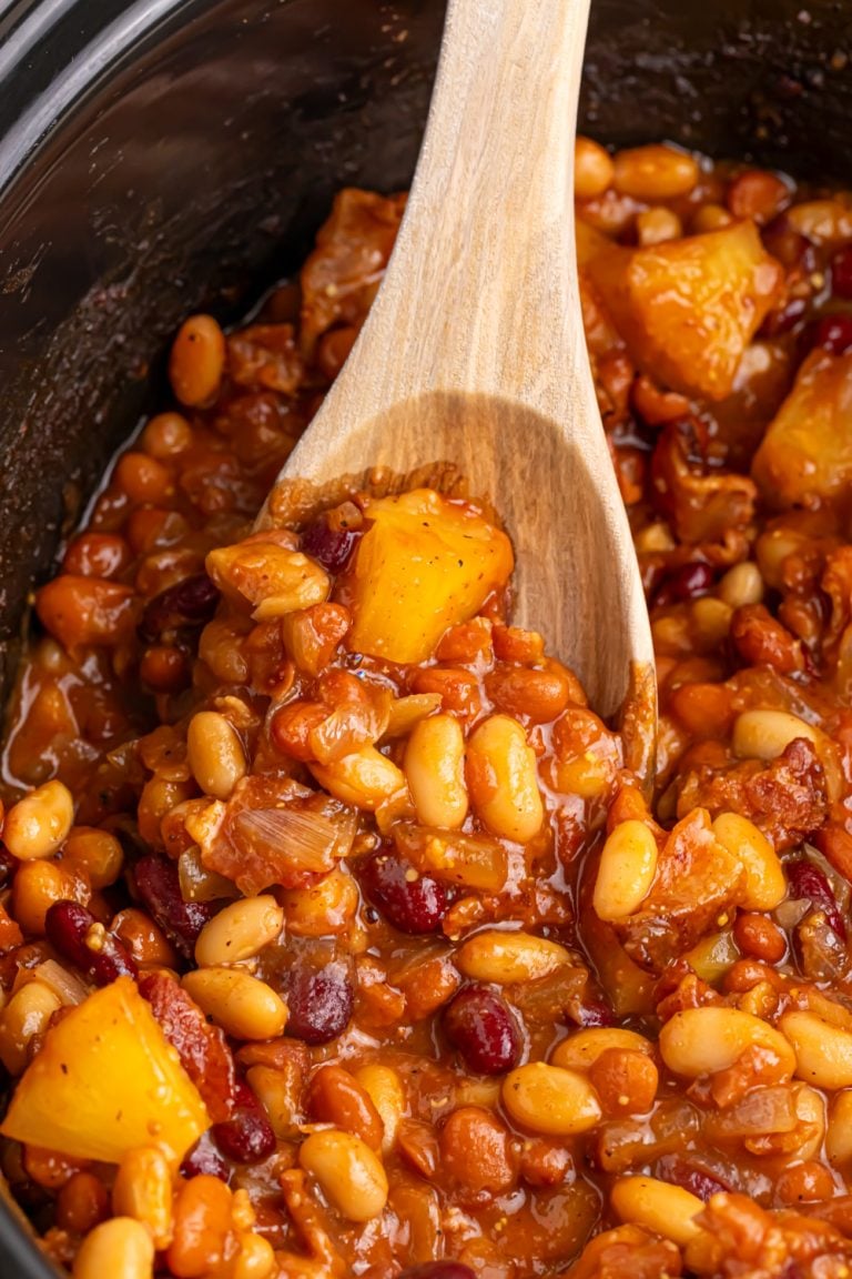 slow cooker hawaiian baked beans in slow cooker with wooden spoon