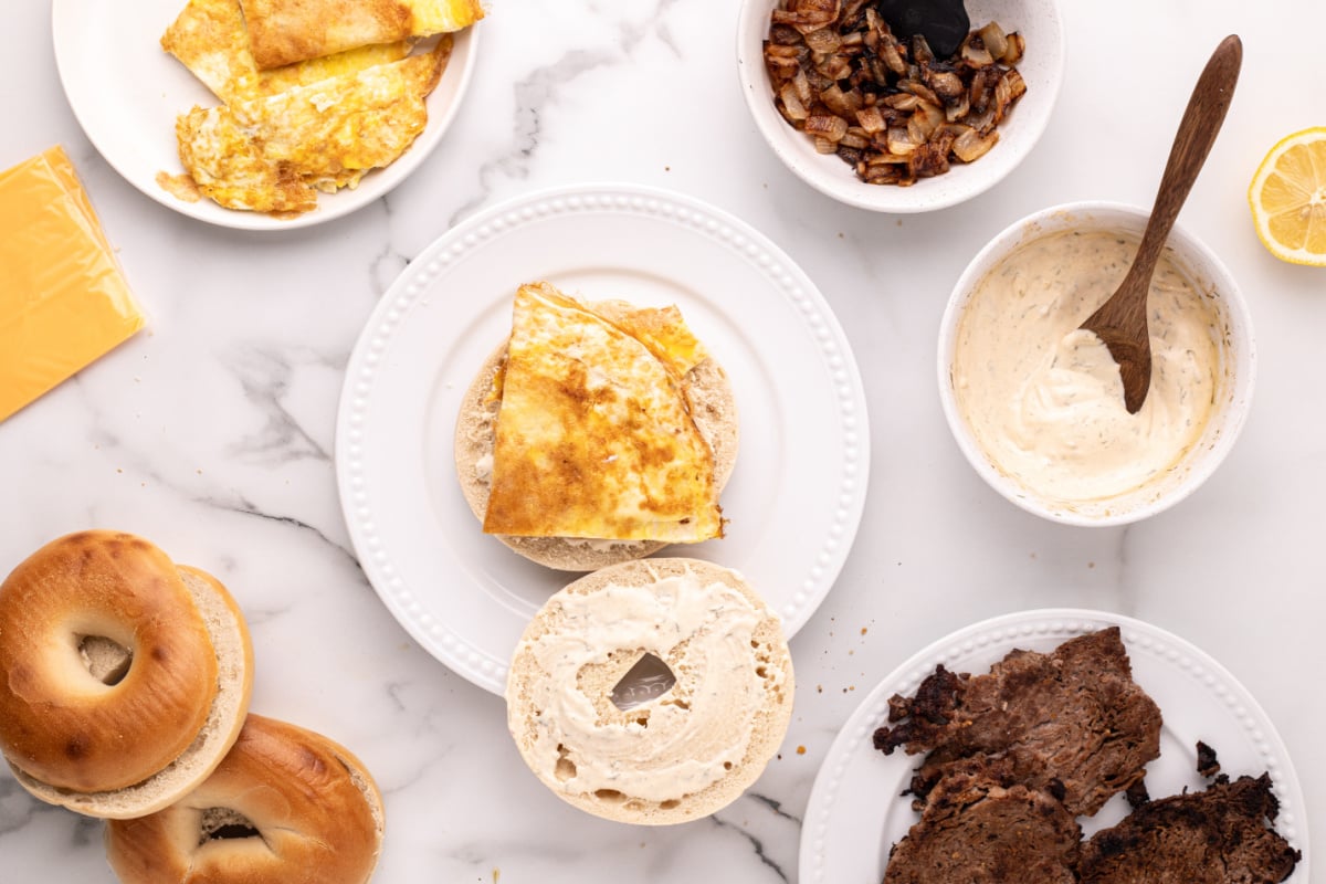 egg placed on sauced bagel