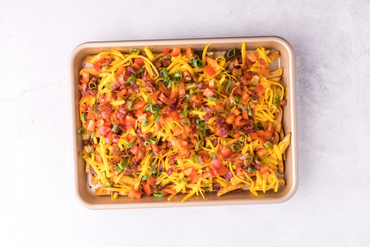 fries topped with shredded cheese, bell pepper, bacon and green onions. 