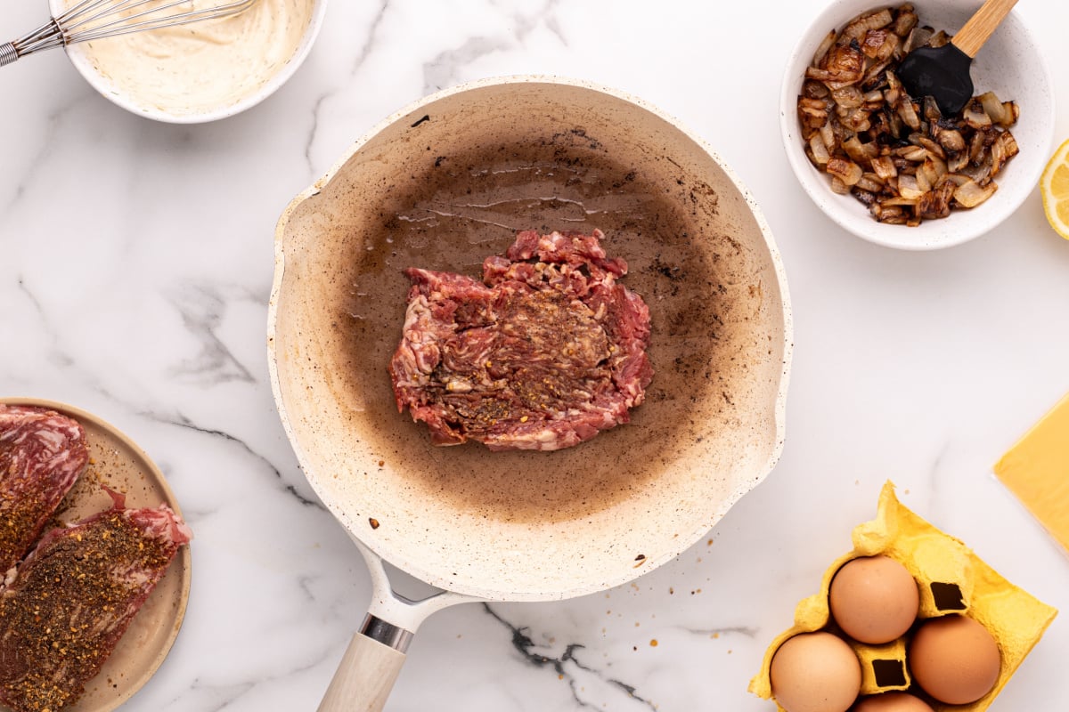cooking steak in pan