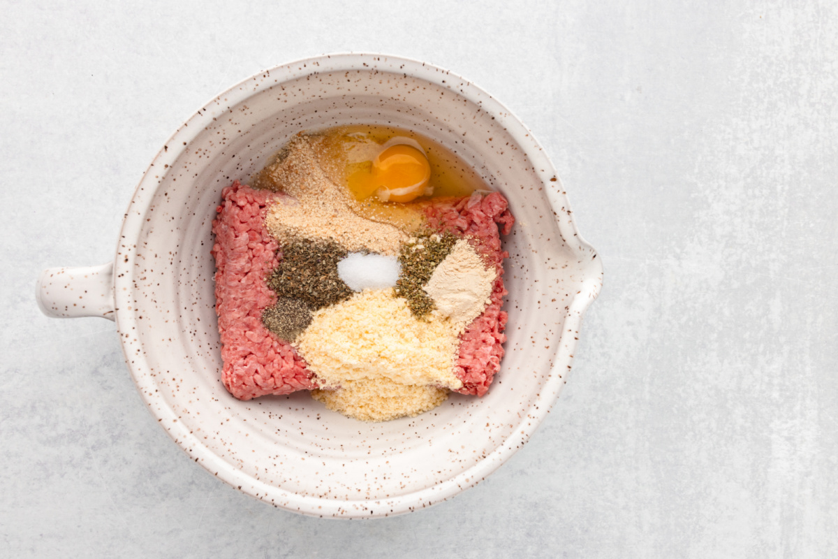 mix ground beef, breadcrumbs, Parmesan cheese, oregano, basil, garlic powder, salt, and pepper in a bowl