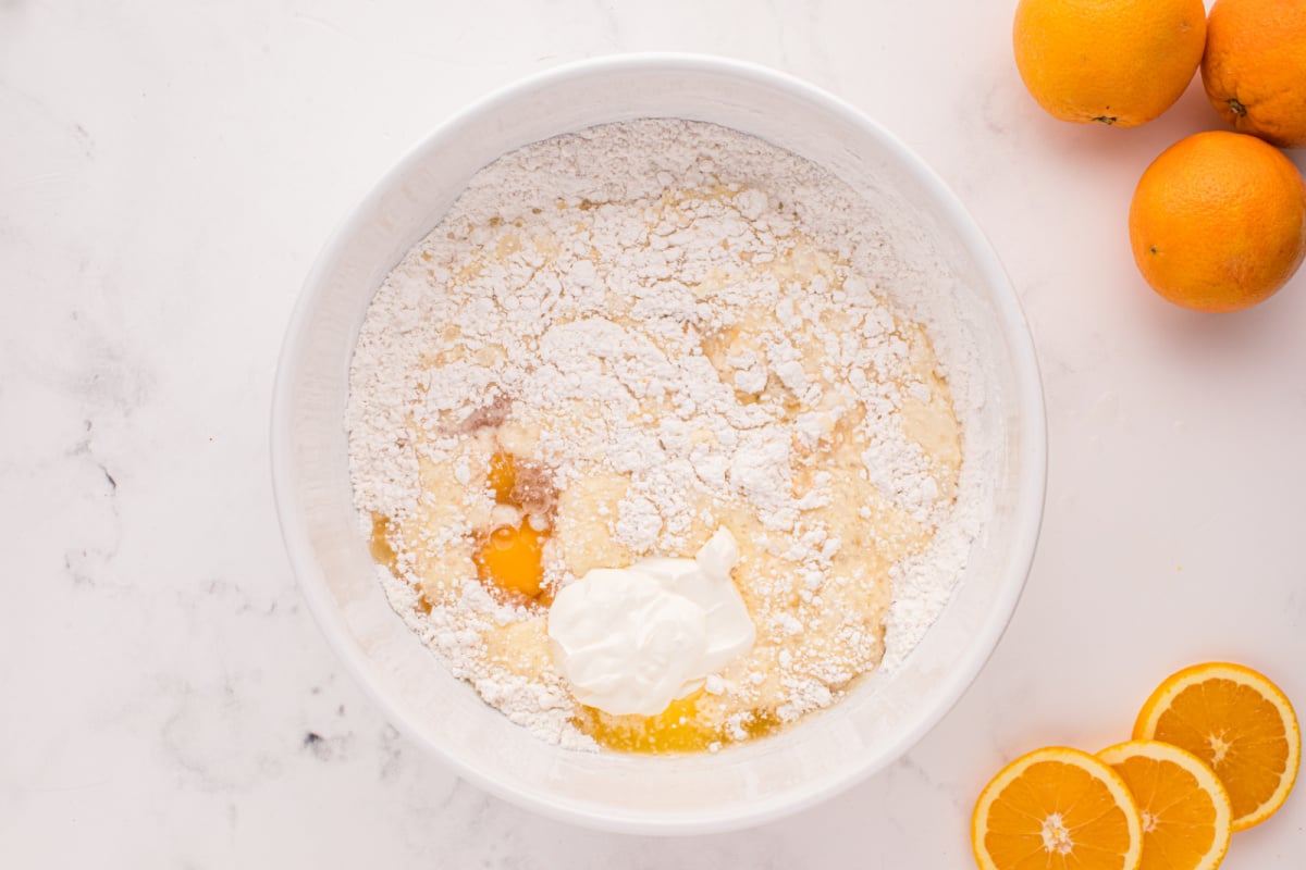eggs, orange juice, melted butter and sour cream added to bowl