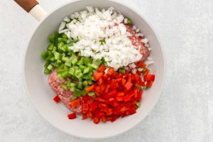 Italian sausage, onion, and bell peppers in pan