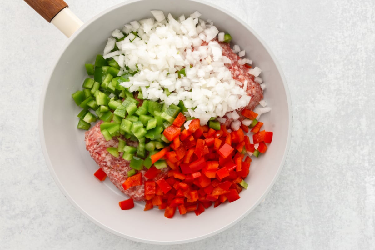 Italian sausage, onion, and bell peppers in pan