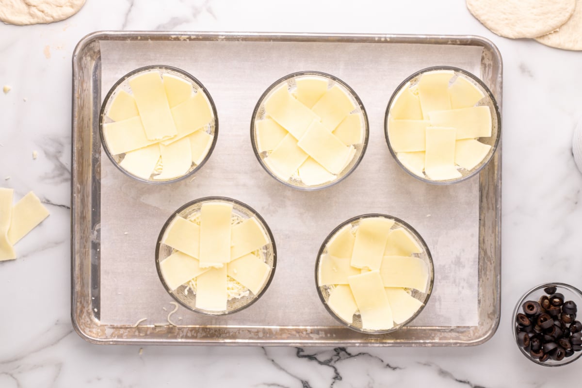sliced cheese placed in bottom of dishes