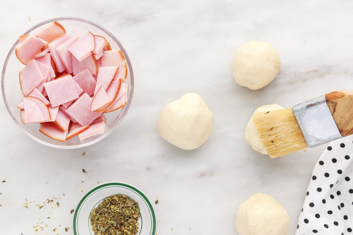 brushing biscuit balls with butter