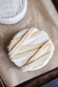 strips of puff pasty laid on brie to look like a mummy