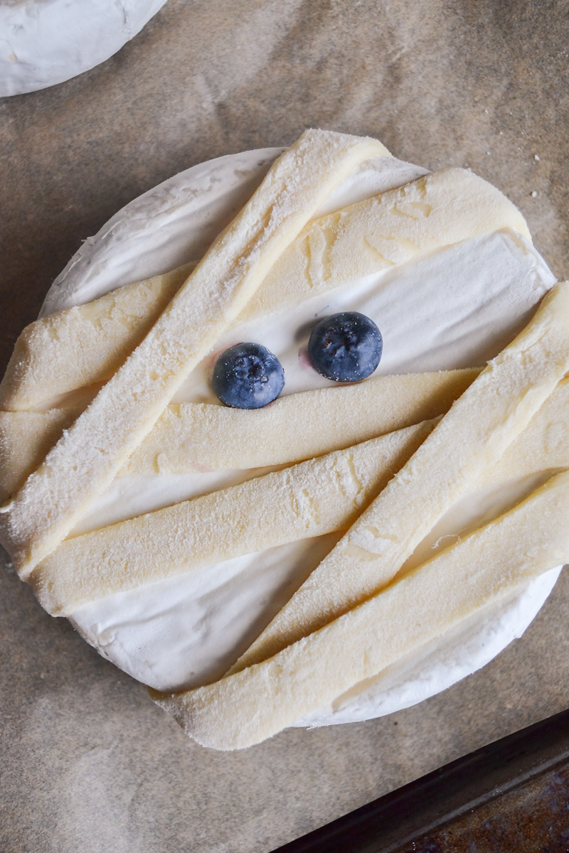 blueberries added to top of brie to look like eyes
