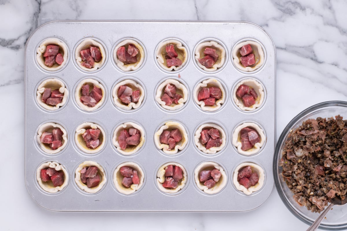 beef pieces added to muffin tin
