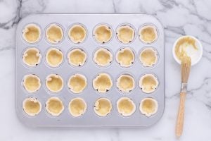 mustard brushed into pasty cups in muffin pan