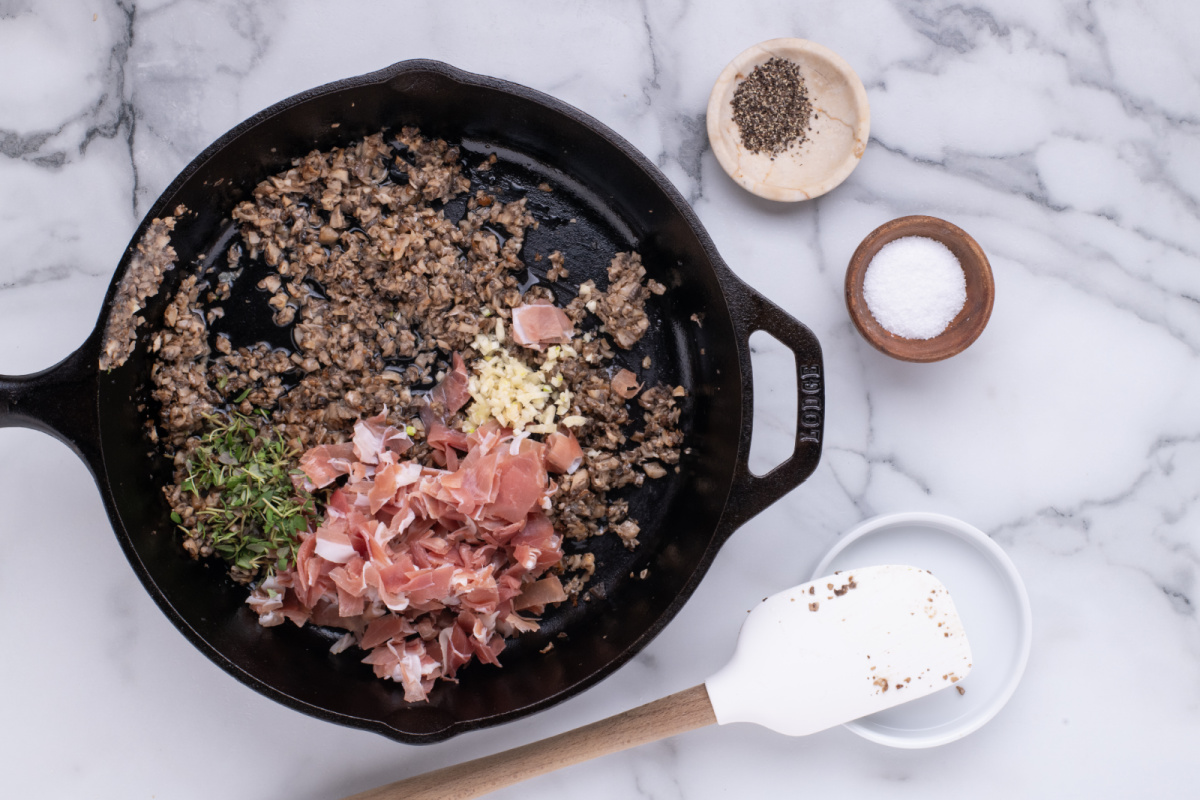 prosciutto, garlic, thyme, and vermouth added to pan with mushrooms