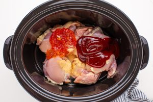 chicken thighs, 1 ½ cups BBQ sauce, Fireball and pepper jelly placed into slow cooker
