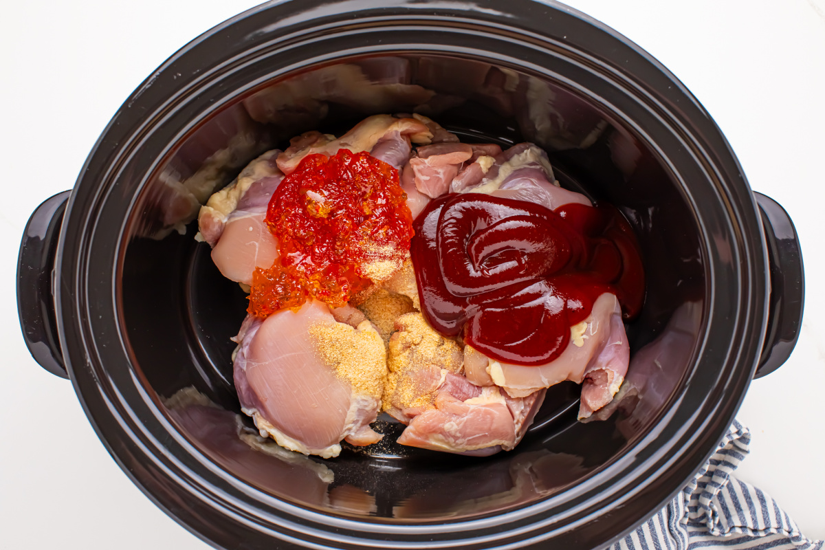 chicken thighs, 1 ½ cups BBQ sauce, Fireball and pepper jelly placed into slow cooker