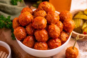 Slow Cooker Hot Honey Meatballs in a bowl with pickles
