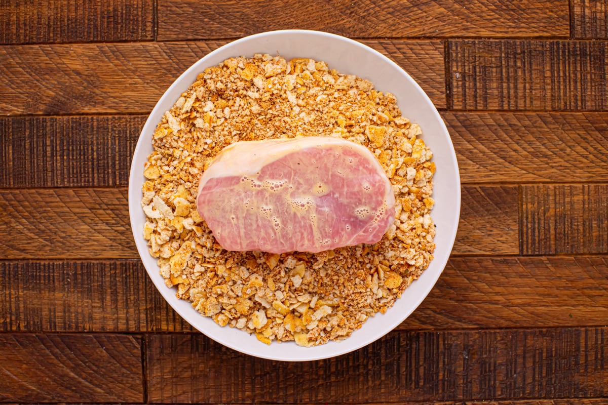 coating pork chop with cracker mix