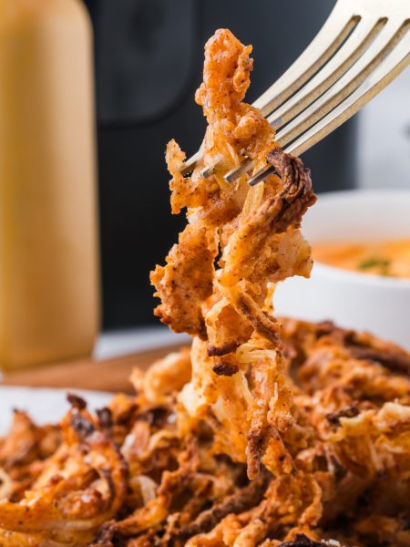 Air Fryer Onion Strings picked up with a fork