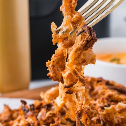 Air Fryer Onion Strings picked up with a fork