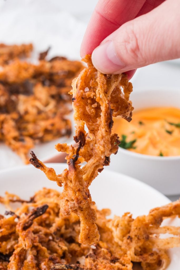 fingers picking up onion rings