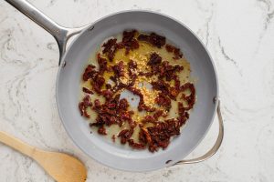 butter, garlic and sun dried tomatoes in a pan