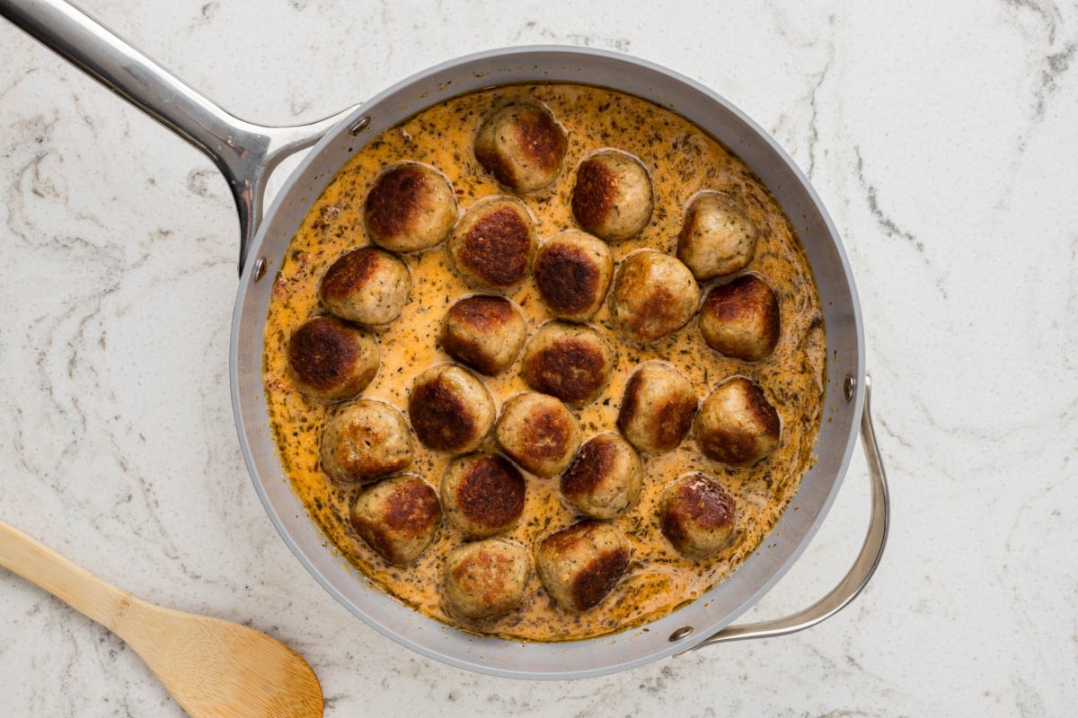 meatballs added to sauce in pan