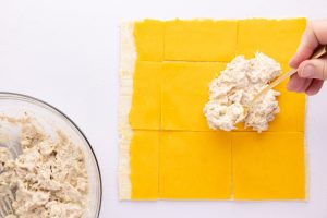 puff pastry rolled out with sliced cheese on top and tuna mixture