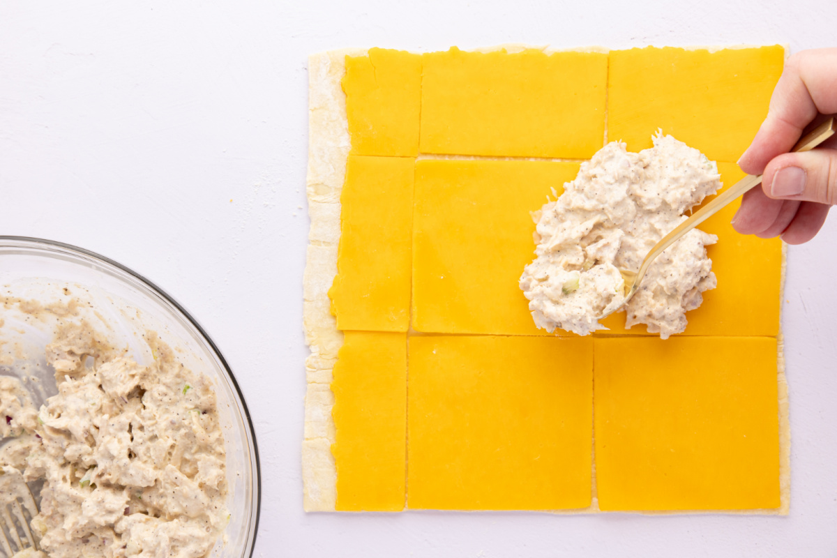 puff pastry rolled out with sliced cheese on top and tuna mixture