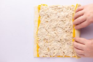 rolling up puff pastry with cheese tuna mixture