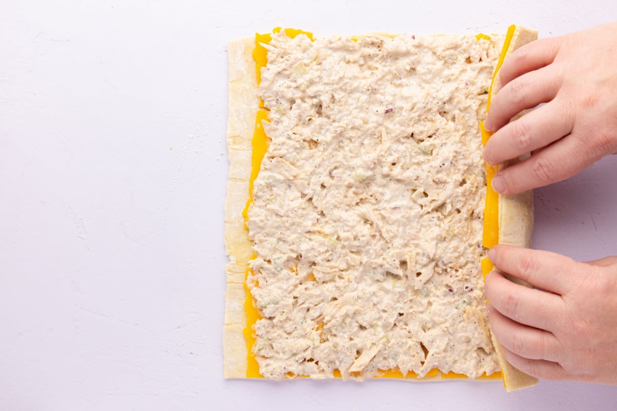 rolling up puff pastry with cheese tuna mixture
