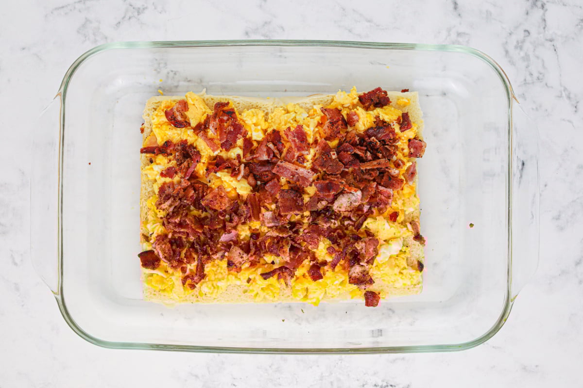 chopped bacon placed on top  of eggs