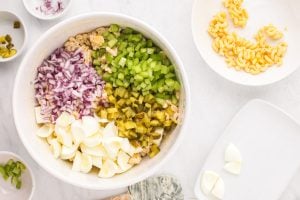 chopped egg whites, celery, red onion, and pickles added to the bowl