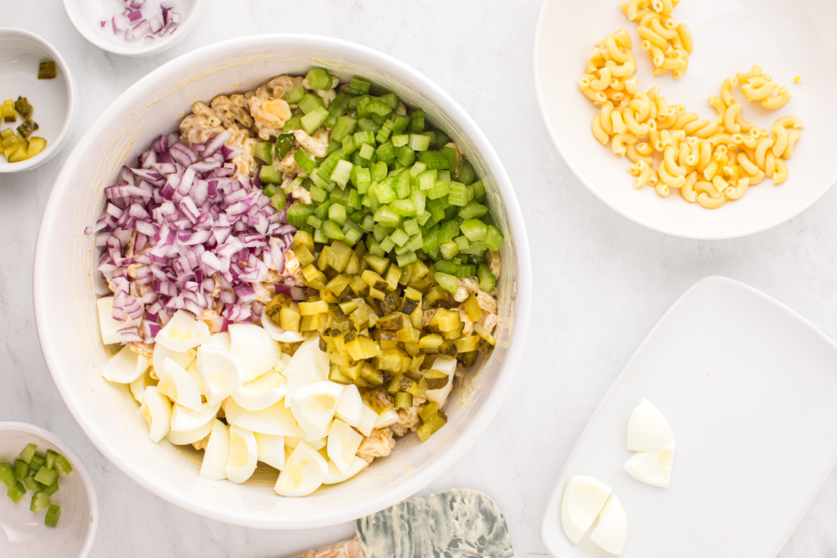 chopped egg whites, celery, red onion, and pickles added to the bowl