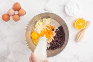 unsalted butter, zest, egg, dried cranberries, and tempered milk added to the bowl