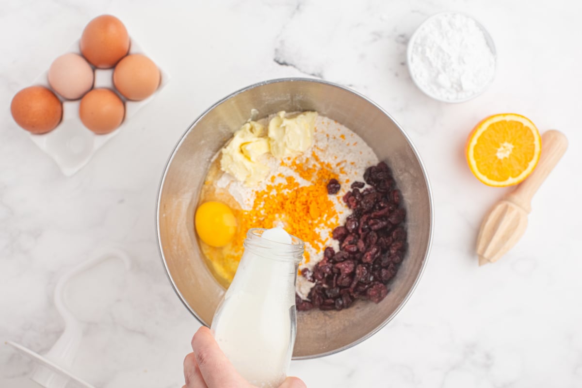 unsalted butter, zest, egg, dried cranberries, and tempered milk added to the bowl