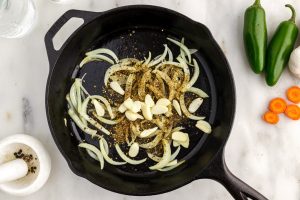 sliced garlic, cumin, oregano, and salt added to the pan