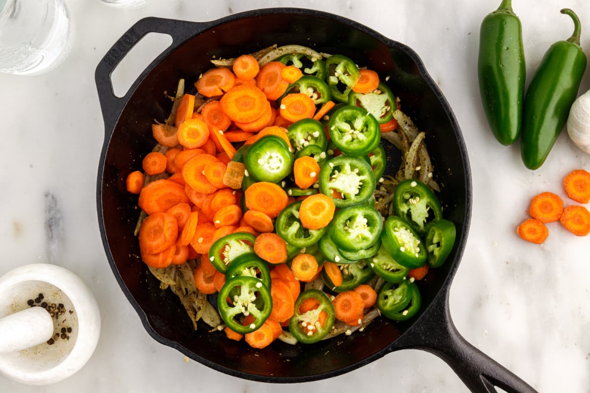 Thinly sliced ​​carrots and jalapeno to the pan