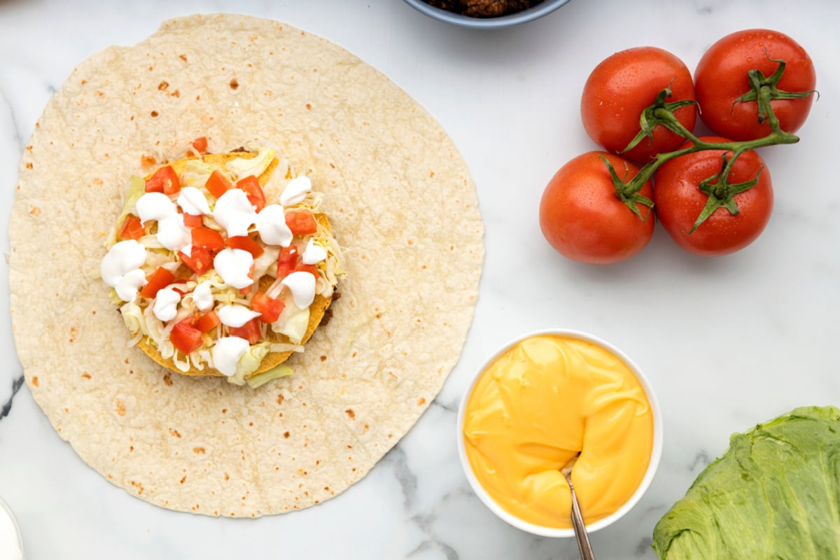 Add lettuce, tomatoes and sour cream to the top of lettuce