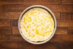 dough in pan with olive oil on top