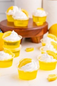 Lemon Drop Jello Shots topped with whipped cream and lemon slice