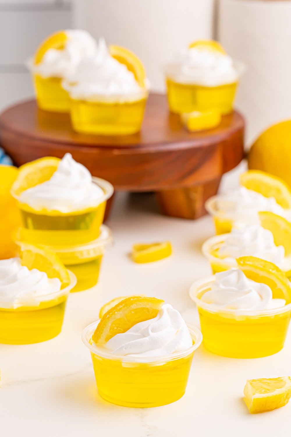Lemon Drop Jello Shots topped with whipped cream and lemon slice