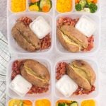 baked potatoes in lunchboxes with cheese, bacon and mixed veggies