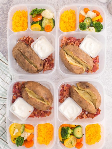 baked potatoes in lunchboxes with cheese, bacon and mixed veggies